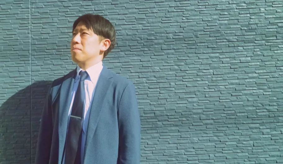 壁の前に立つサラリーマン