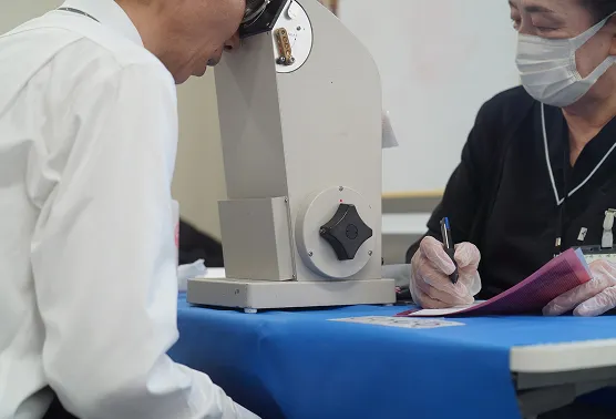 視野検査の機械に顔を乗せる男性