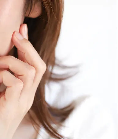 顔の皮膚を触る女性