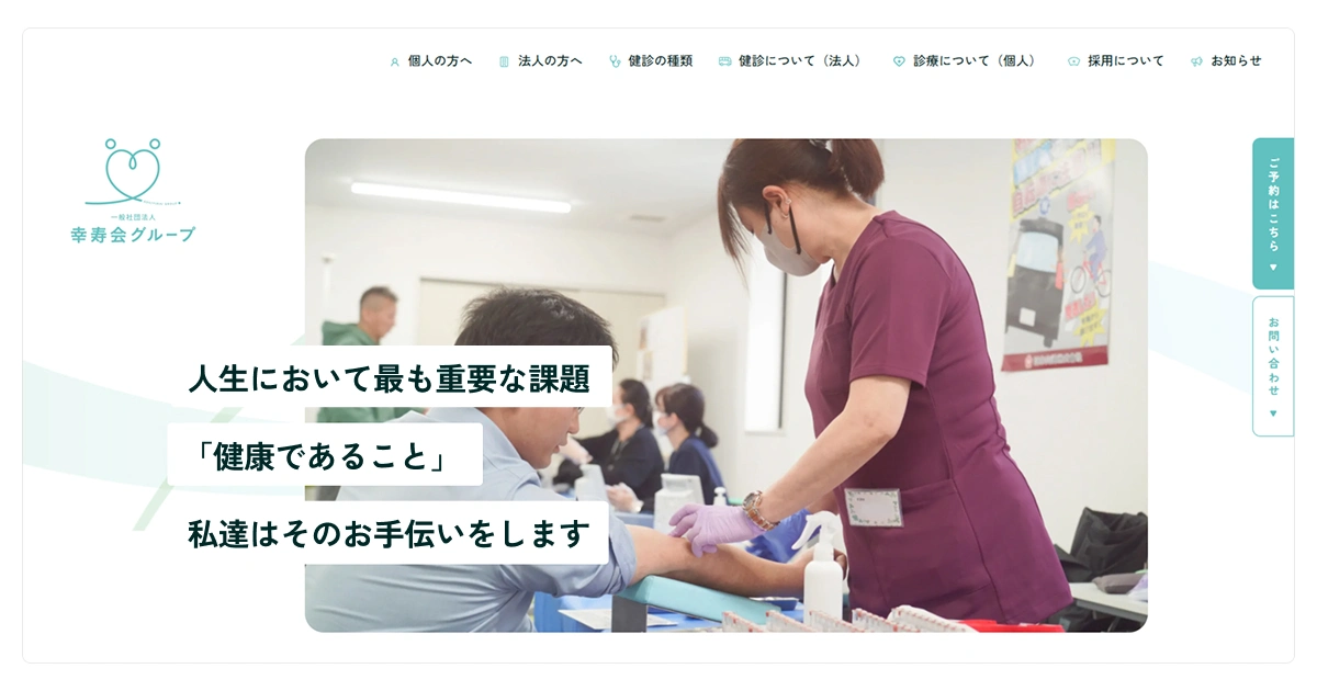 健康診断の様子。医療スタッフが、検査を受ける男性の腕に針を刺す準備をしている。背景には、他の受診者と医療スタッフが対応している様子が見える。